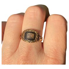 A stunning Georgian era mourning ring in a rare state of complete preservation, with all the hallmarks, original inscription, enamel and hair. All in original condition. It has a central locket compartment glazed with its original rounded, beveled glass and accessible only by a jeweler. This has a black enamel inner bezel and an engraved gold outer bezel. The beautiful hand engraved detailing continues throughout the piece. The back of the ring face is inscribed: "James Slemeck Died 16 Feb"y 1822 Aged 80.” The inside shank has four hallmarks, including the date letter "f" for 1821, 18 for the gold contest, SR for maker's mark, the London office assay marks and the British hallmarks. Measurements: Front locket part: 13 mm W x 11.5 mm H x 3 mm D Band: 4 mm W Weight: 4.2 grams Size: 7.75 (we The Ring Face, Georgian Era, Letter F, La Face, Beveled Glass, Hand Engraving, Black Enamel, Beautiful Hand, Locket