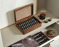 an open wooden box filled with lots of teas on top of a white counter