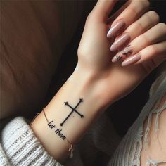 a woman's arm with a cross tattoo on it