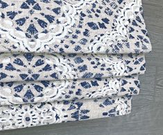 the blue and white fabric is folded on top of each other, with an intricate pattern