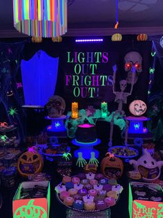 a table filled with lots of halloween decorations and lights on it's walls in the dark