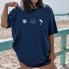 This beach shirt is cute and simple. Featuring some of the best things about the beach - ocean waves, sunsets, palm trees, and sea turtles. This would be a perfect beach vacation shirt or a gift for anyone who loves the ocean or beach!  We are so happy you found our shop! See our other listings for more colors and designs. Please reach out if you're looking for something specific that we don't currently offer. ✨Product Details✨ Our shirts are Bella + Canvas 3001 Adult Unisex Short Sleeve Tee  Features:  ーLight, breathable, soft fabric + quality print  ーDual side seams for durability  ーRibbed knit collars.  ーShoulder taping.  ーEasy to remove tear-away label. Colors: ー Please see color chart in photos. ー Shirt colors may appear slightly different on different computer screens. We strive our Beach Tshirt Outfit, Cheap Beachy T-shirt For Beach, Blue Beachy T-shirt For Beach Season, Beachy T-shirt For Beach Vacation, Affordable Beachy T-shirt For Beach, Beachy Cotton T-shirt For Beach Season, Surfer Clothes, Beach Shirt Design, Beach Outfit For Women