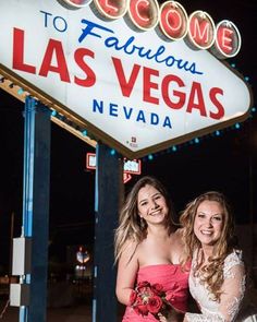 two beautiful young women standing next to each other in front of the las vegas sign