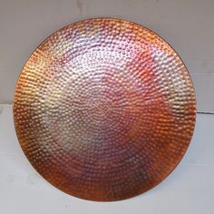 a large metal plate sitting on top of a white wall