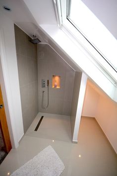 a bathroom with a skylight above it and a white rug on the floor below