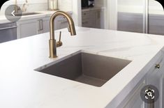 a kitchen with marble counter tops and gold faucets on the sink's side