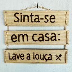 three wooden signs hanging on a wall with spanish words written in black and white ink