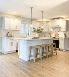 a kitchen with white cabinets and wooden floors