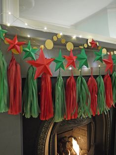 christmas decorations hanging from the mantle in front of a fire place