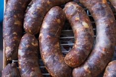 several large sausages are on a grill