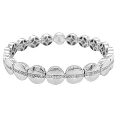 An epitome of understated luxury, this 18kt white gold bracelet is a masterpiece of craftsmanship and refinement. It’s elastic design ensures a comfortable fit while showcasing a continuous, unbroken circle of diamonds that envelops your wrist in a shimmering embrace. A symbol of timeless elegance, this bracelet exudes an aura of sophistication and grace. Crafted from 18kt White Gold, the magnificent stretch bracelet comes enriched with 77 Diamonds Round Brilliant Shape Color G Clarity VS 0.54 c Luxury White Gold Fine Jewelry Crystal Bracelet, Modern Platinum Bracelets In Diamond White, Diamond Bracelet With Polished Finish, Modern Platinum Bracelet In Diamond White, Modern Platinum Bracelets With Single Cut Diamonds, Modern Platinum Bracelet With Single Cut Diamonds, Modern White Platinum Bracelets, Modern Flexible Round Diamond Bracelet, Polished Diamond Tennis Bracelet