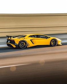 a yellow sports car driving down the road