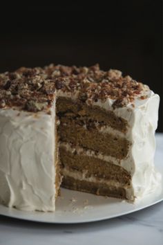 there is a cake with white frosting and walnuts on the top, cut in half