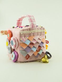 a pink purse with an elephant on the front and other items around it, including bells