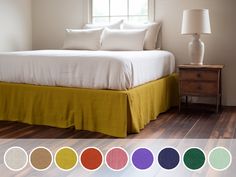 a bed with white sheets and yellow bedspread next to a lamp on a wooden floor