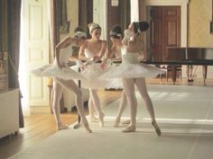 four ballerinas in white tutus are posing for the camera