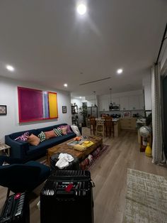 a living room filled with furniture and a painting on the wall