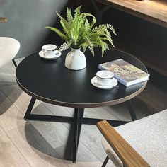 a table with two chairs and a plant on it in front of a window next to a bench