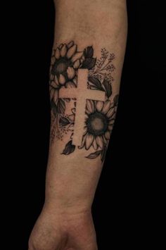 a cross and sunflowers tattoo on the arm