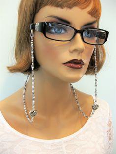 Silver Eyeglass Chains with Hearts in two different styles, handmade by Ralston Originals. Ralston Originals was the first to add the lobster clasp at the end of the eyeglass chain to join together to make a Necklace. Brilliant! You get two pieces of jewelry in one, a eyeglass chain for your reading glasses, or sunglasses, and a beaded necklace as well!! The uniqueness about this Eyeglass Chain is the silver hearts on the chain. When you wear this eyeglass chain with your glasses, the hearts han Beaded Metal Glasses Chains As Gift, Metal Beaded Glasses Chains As Gift, Metal Beaded Glasses Chains For Gifts, Bohemian Glass Jewelry With Heart Beads, Adjustable Glass Jewelry With Heart Beads, Silver Beaded Glasses Chains With Round Beads, Silver Bohemian Glasses Chains Gift, Silver Glass Jewelry With Beaded Chain, Silver Beaded Metal Glasses Chain