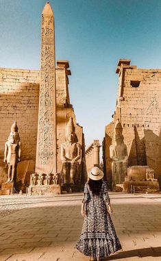 a woman standing in front of an egyptian temple