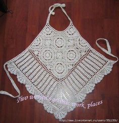 a white crocheted apron on a wooden floor with a string tied around it