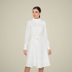 "A collared midi dress featuring a button front closure (imitation), fabric belt, and a fit and flare silhouette. - fit and flare silhouette - high rounded collar - knee length (midi) - long sleeves with cuffs - fabric belt - covered button front decor - concealed zipper closure - lined bodice and skirt - color: white Fiber: 60% viscose, 35% polyester, 5 % elastane, Lining - 95 % viscose, 5% elastane. For size S:dress length- 40,0 \" (102 cm), sleeve length 24,21\" (61,5 cm) Our model wears size Long Sleeve White Midi Dress, Long Sleeve White Dress, Wedding Dress Casual, Bridesmaids Jumpsuits, High Collar Dress, Modest Dresses For Women, Courthouse Wedding Dress, Midi Dress Long Sleeve, Temple Dress