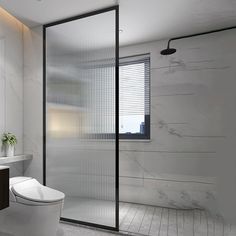 a bathroom with a toilet, sink and shower stall in white marbled tile flooring