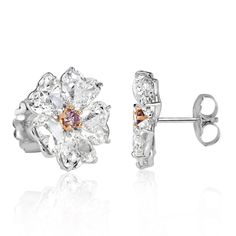 These 18k white gold diamond earring studs are feminine and truly one-of-a-kind. This design showcases 10.64ct of diamonds that are certified at G-I colors and VS2-SI2 clarities. The stunning heart shaped diamonds are styled as floral petals that are individually GIA certified, weighing in at just over 1 carat each. In the center of the design is a rare fancy pink diamond that is secured by rose gold prongs. These beauties are not only extremely unique but posess a beautiful allure that will mes Luxury Heart Cut Diamond Earrings, Luxury White Diamond Platinum Earrings, Luxury White Platinum Diamond Earrings, Luxury White Diamond Cut Cluster Earrings, White Diamond Heart-cut Earrings, Luxury White Cluster Earrings With Diamond Cut, Luxury White Cluster Earrings With Prong Setting, White Luxury Cluster Earrings With Prong Setting, White Diamond Heart Cut Earrings