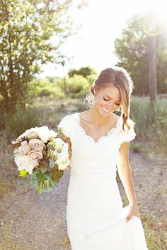 a woman in a wedding dress holding a bouquet and smiling at the camera with text that reads, cap sleeve v - neck sheath chiffon dress with lace bodice and sash