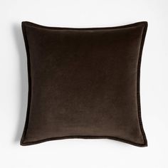 a dark brown velvet pillow on a white wall with a black border around the edges