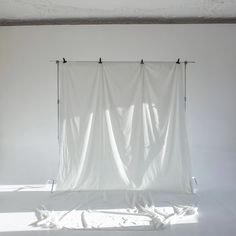 an empty room with a white curtain hanging from the ceiling