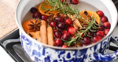 cranberries, oranges and spices are in a pot on the stove