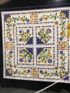 a white quilt with blue and yellow flowers on it