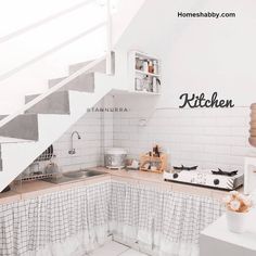 there is a kitchen with white walls and stairs