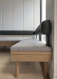 a black and white striped bench sitting next to a wall