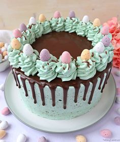 a chocolate cake with green frosting and eggs on top is sitting on a plate