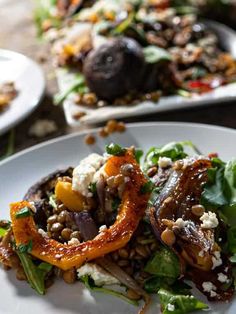 a white plate topped with lots of food on top of a wooden table next to other plates