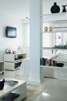 a living room filled with furniture and a flat screen tv mounted to the side of a wall