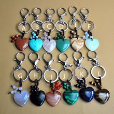 a collection of heart shaped key chains with letters and charms attached to them, sitting on a table