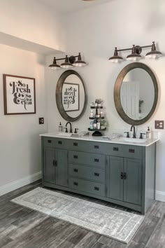 a bathroom with double sinks and two mirrors on the wall above them is shown in this image