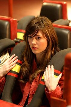 a woman sitting in a chair with her hands on her chest