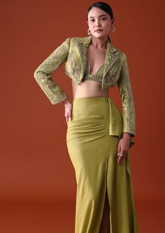 Experience sophistication with our emerald green indo western ensemble. Featuring a citrus green draped skirt and bustier paired with an embroidered short jacket that is delicately ornate with cutdana and elegant sequin accents. Exuding a timeless charm with its flattering silhouette and vibrant color this three-piece outfit evokes a sense of fresh elegance. Dry clean only if required. Slight variation in color is possible due to digital photography. Jacket Indowestern Outfit, Blazer With Skirt Indian, Indo Western Skirt Outfits, Skirt With Jacket Outfit, Indian Blazer Outfit Women, Trending Indo Western Outfits, Indo Western Dress Illustration, Drape Dresses Indo Western, Designer Indo Western Outfits For Women