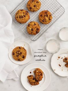 chocolate chip pumpkin cookies with milk on a cooling rack and white plates next to them