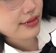 a woman wearing glasses and nose piercings