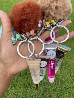 a person holding several different items in their hand, including an animal keychain