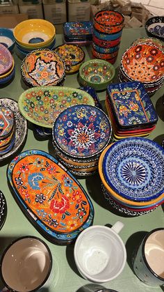 many colorful plates and bowls on a table