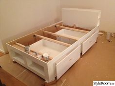 an unfinished bed frame with drawers in the middle