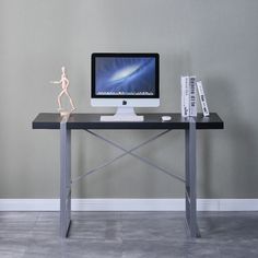 a computer monitor sitting on top of a desk next to a bookshelf filled with books