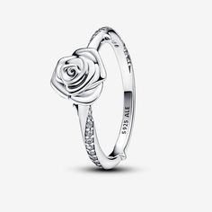 Crafted in sterling silver, the Rose in Bloom Ring represents the timeless gesture of gifting a rose to someone special. Blooming rose petals delicately layer on the ring's surface, creating a stunning three-dimensional effect. The band, adorned with a swirling pavé row, radiates classic elegance. The raised thorns add a extra level of detail, turning a classic symbol into a unique statement. Inspired by the universally recognized symbolism of a rose, this ring captures the essence of love and m Pandora Rose, Charms Pandora, Pandora Rings, Rose Ring, Pandora Bracelets, Ring Pendant Necklace, Pavlova, Single Earring, Pandora Jewelry